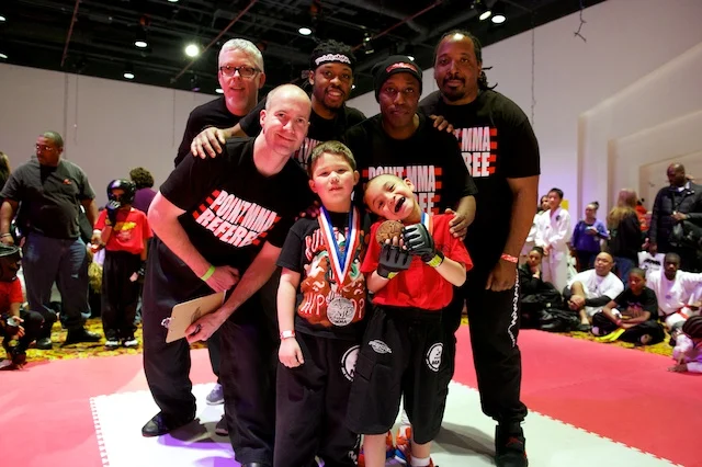 Point MMA coaches with two young medal winners on the tournament mat